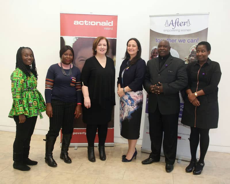 Group photo at an ActionAid Ireland event with diverse participants standing in front of banners.