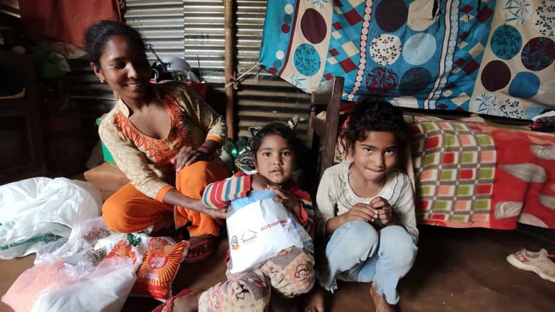 Happy family sitting together indoors, sharing smiles and cozy moments in a vibrant, decorated room.