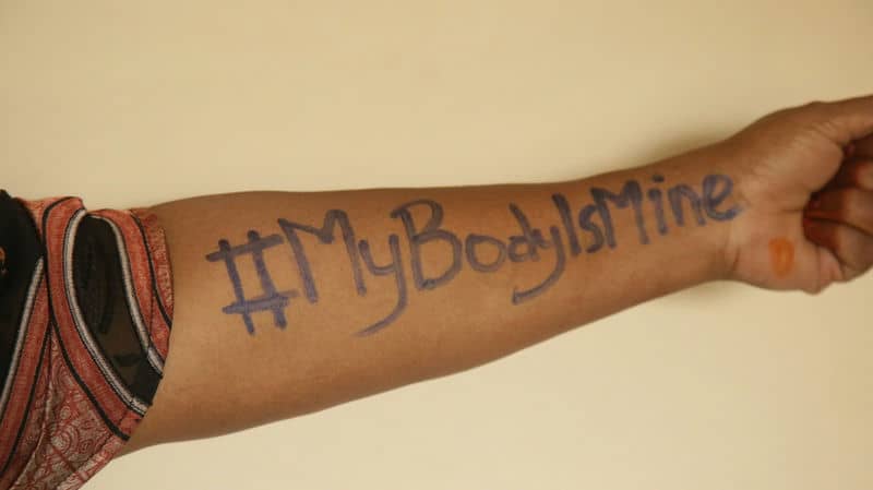 Arm with handwritten message '#MyBodyIsMine' advocating for body autonomy and empowerment.