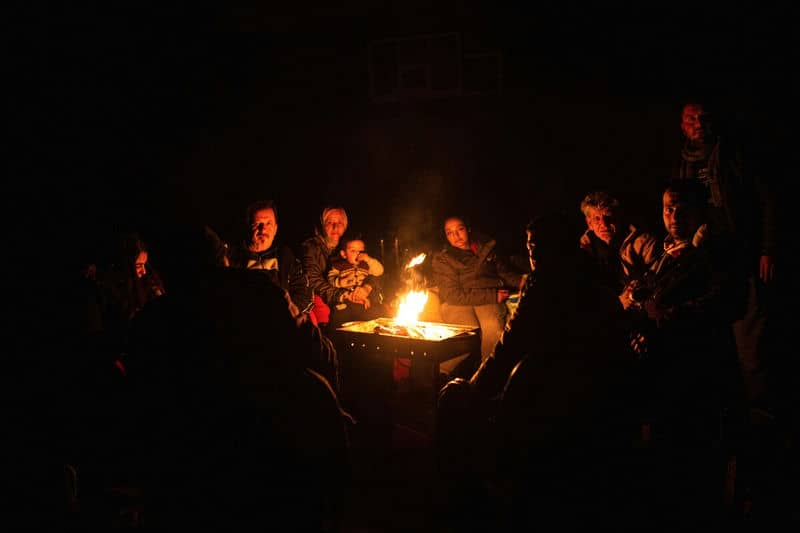 People gathered around a warm campfire at night, sharing stories and enjoying the cozy glow under the starry sky.