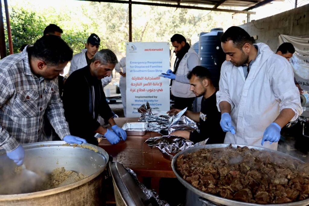 Volunteers preparing food packages for displaced families in Gaza at an emergency response center.