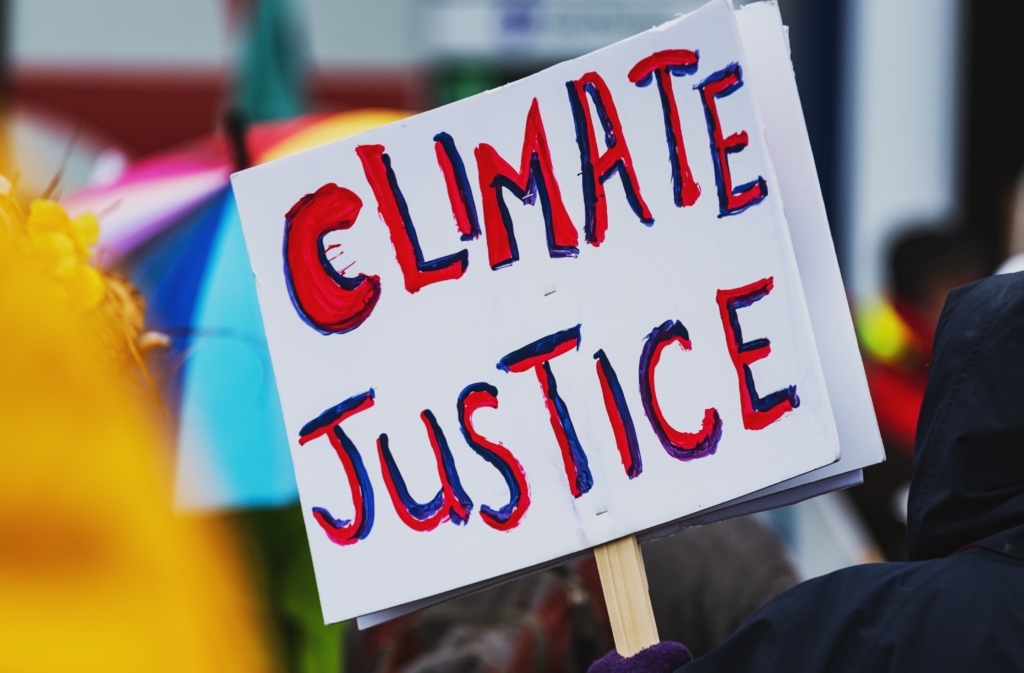 Protest sign advocating for climate justice displayed at a rally, highlighting environmental activism.