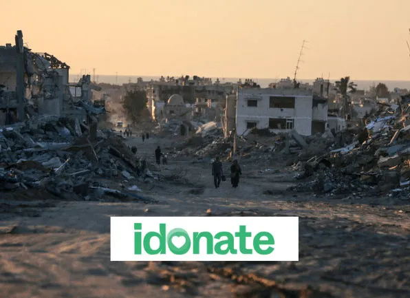 War-torn cityscape at sunset with idonate logo in foreground, highlighting aid and support efforts.