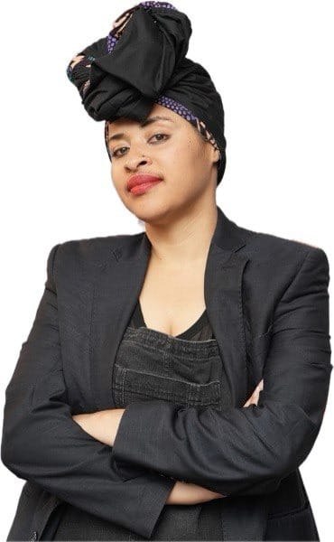 Person in black jacket with crossed arms and headscarf, confidently looking forward. White background.