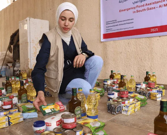 Woman organizing emergency food supplies in Gaza, surrounded by canned goods and oils, aid distribution.