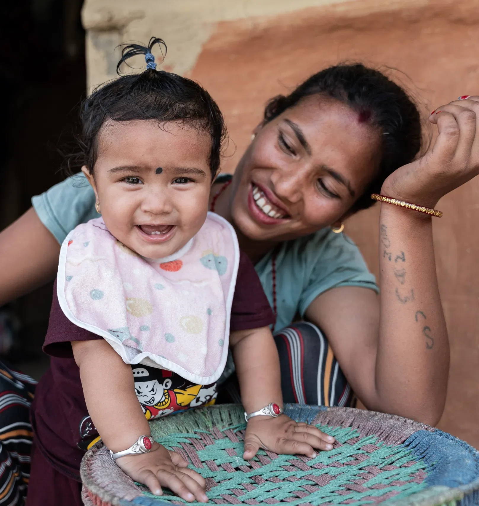 Mother and baby smiling joyfully together at home, showcasing happiness and family bond.